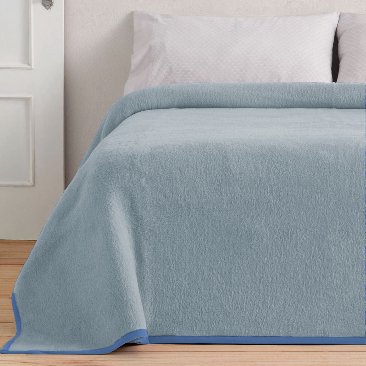 De lichte zijde van de Aabe Isola blauw uitgestald op een bed