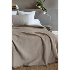 Lamswollen deken gedrapeerd op een bed